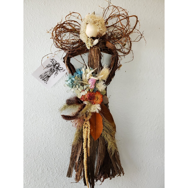 Handcrafted cedar angel wall hanging with dried flowers and rustic twigs