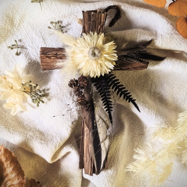 6-inch cedar cross with dried flowers and fern accents on a light fabric background