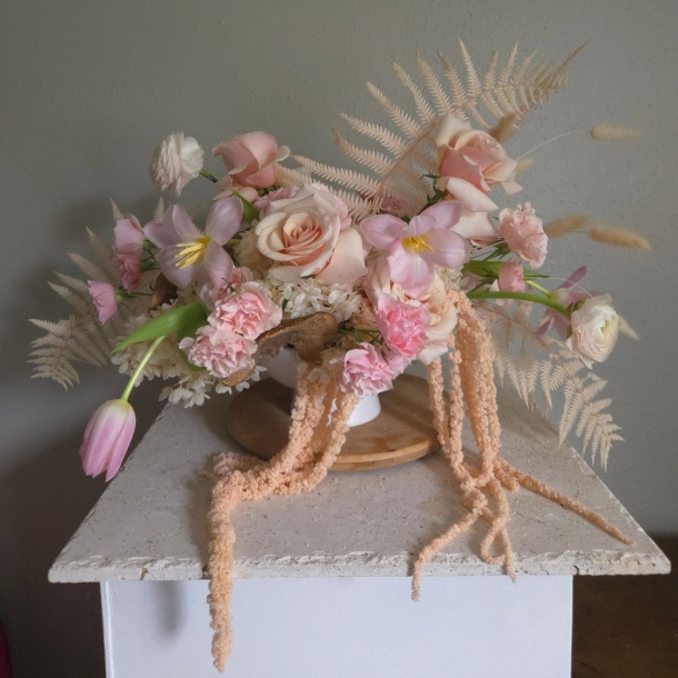 Floria floral arrangement with blush roses, pink tulips, and soft fern accents in a white vase