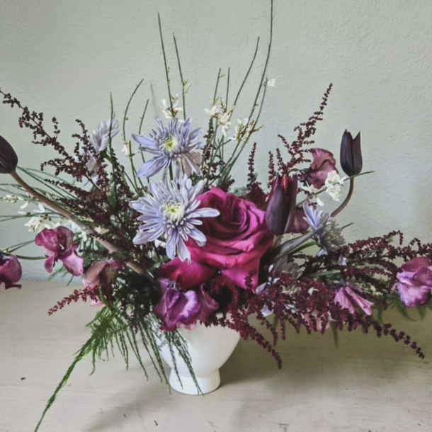 Lumi floral arrangement with magenta rose, purple blooms, and burgundy accents in a white vase